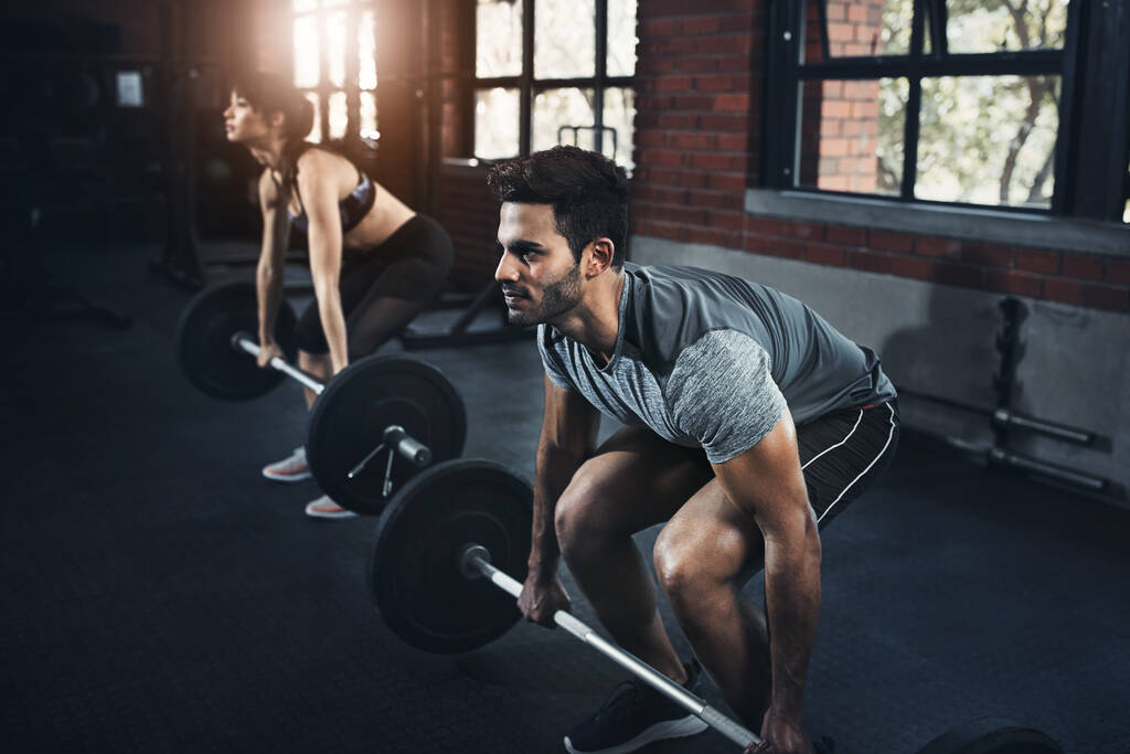 Kohteena suuret lihasryhmät. nuori mies ja nainen treenata painot kuntosalilla - Valokuva, kuva