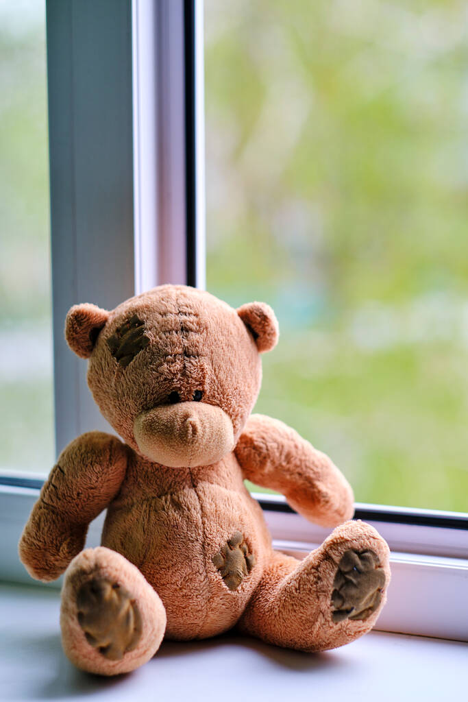 Urso crianças brinquedo macio sentado borda uma janela aberta.Conceito acidentes com crianças - Foto, Imagem