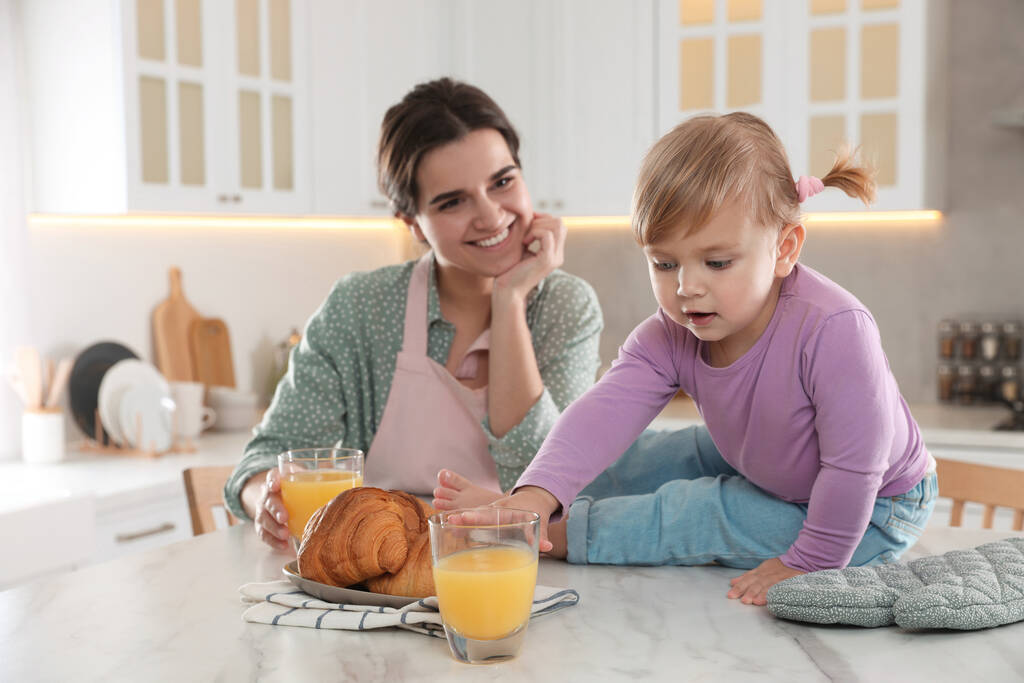 Madre y su hijita desayunando juntas en la cocina - Foto, Imagen