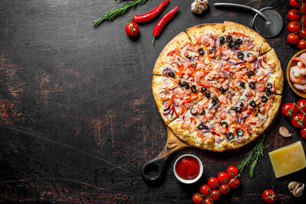 Seafood pizza with a crispy crust. On dark rustic background - Photo, Image