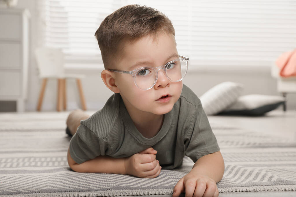 Słodki chłopczyk w okularach na podłodze w domu - Zdjęcie, obraz