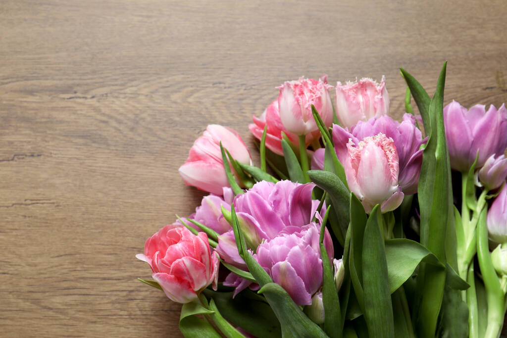 Hermoso ramo de flores de tulipán de colores en la mesa de madera, disposición plana. Espacio para texto - Foto, imagen