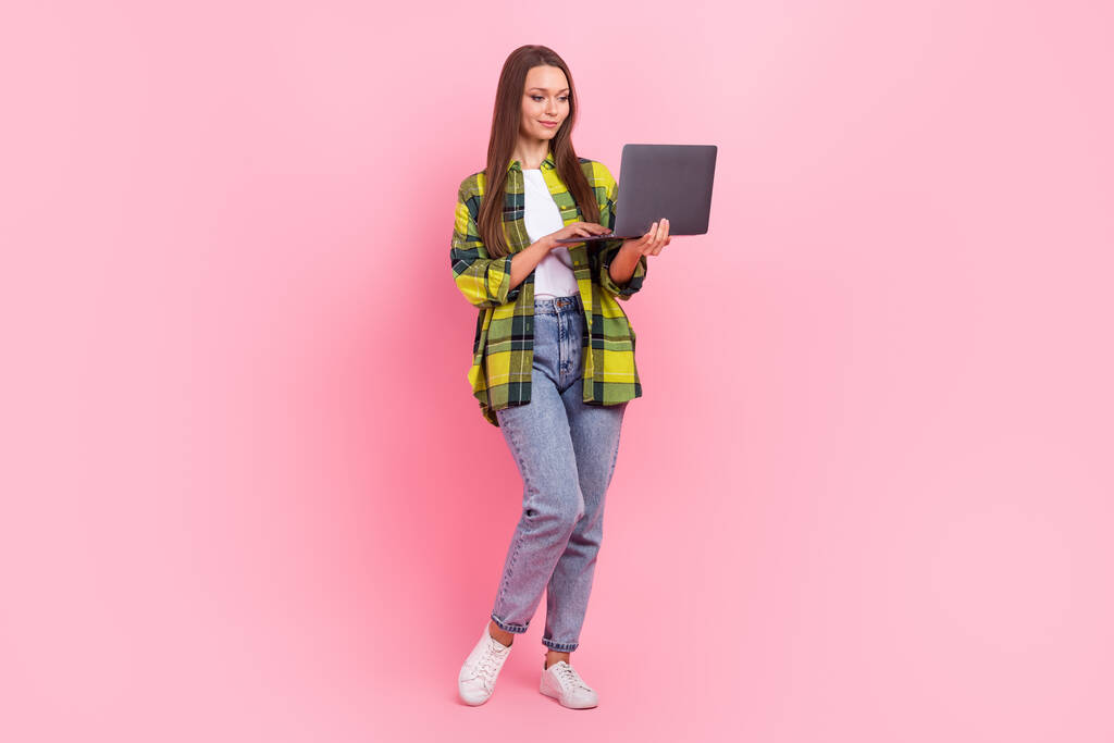 Πλήρης φωτογραφία μεγέθους του συμπαθητικού θετικού κοριτσιού κρατήσει χρήση ασύρματο netbook απομονωμένο σε ροζ φόντο χρώμα. - Φωτογραφία, εικόνα