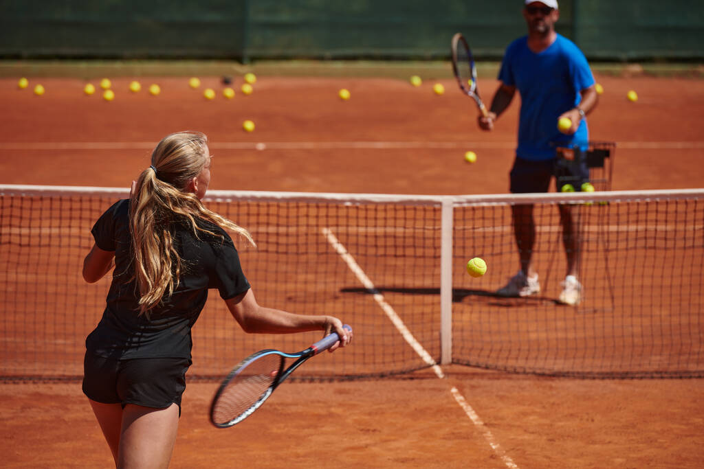 プロのテニス選手と彼女のコーチのトレーニングは、テニスコートで晴れた日に。プロのテニス選手のトレーニングと準備. - 写真・画像