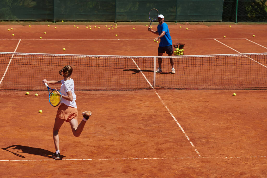 Uma tenista profissional e seu treinador treinando em um dia ensolarado na quadra de tênis. Treinamento e preparação de um tenista profissional. - Foto, Imagem