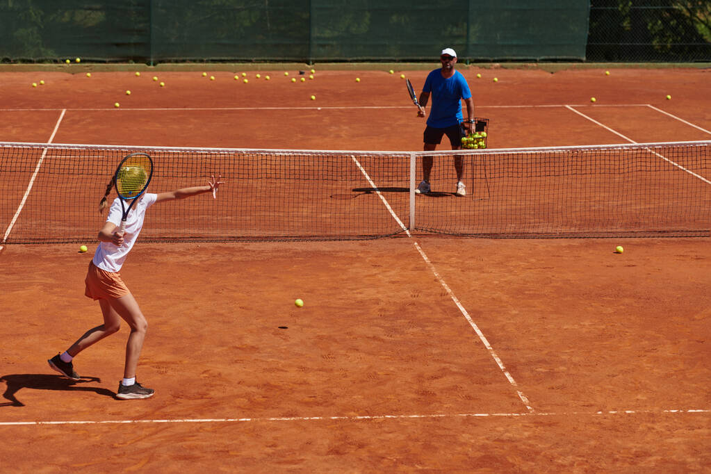 Tennispelaaja ja hänen valmentajansa treenaavat aurinkoisena päivänä tenniskentällä. Ammattimaisen tennispelaajan koulutus ja valmentaminen. - Valokuva, kuva