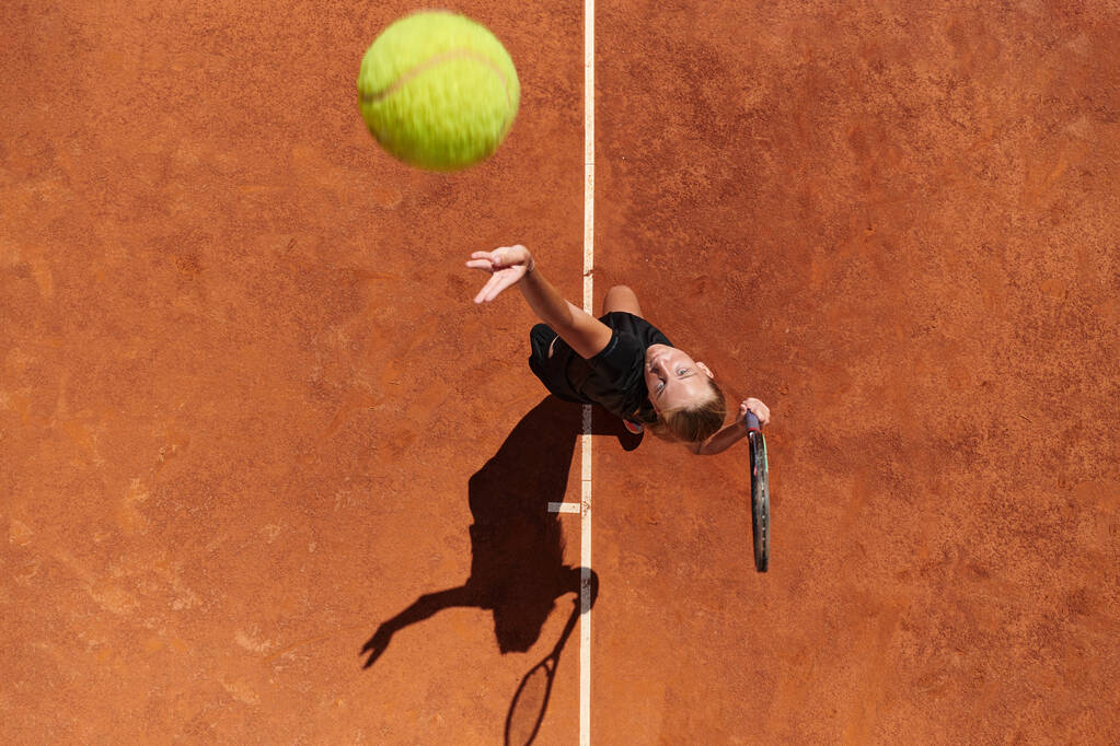 Top näkymä ammatillinen naistennispelaaja palvelee tennispallo kentällä tarkasti ja teho.  - Valokuva, kuva