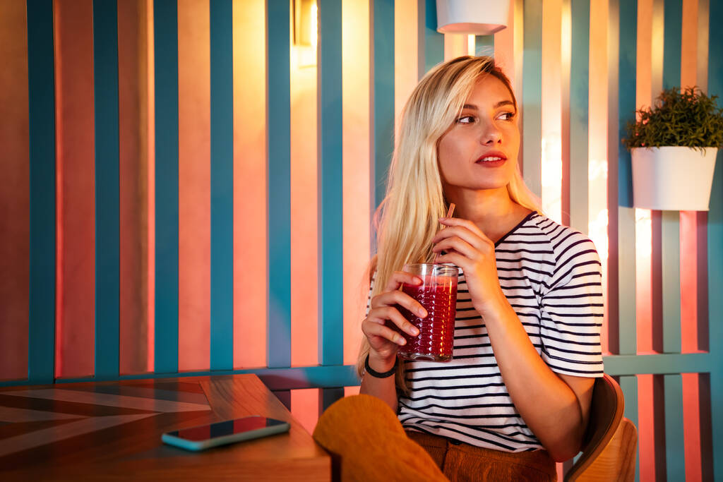 Portrét zdravé mladé šťastné ženy popíjející džus v kavárně. Lidé zdraví životní styl koncept - Fotografie, Obrázek