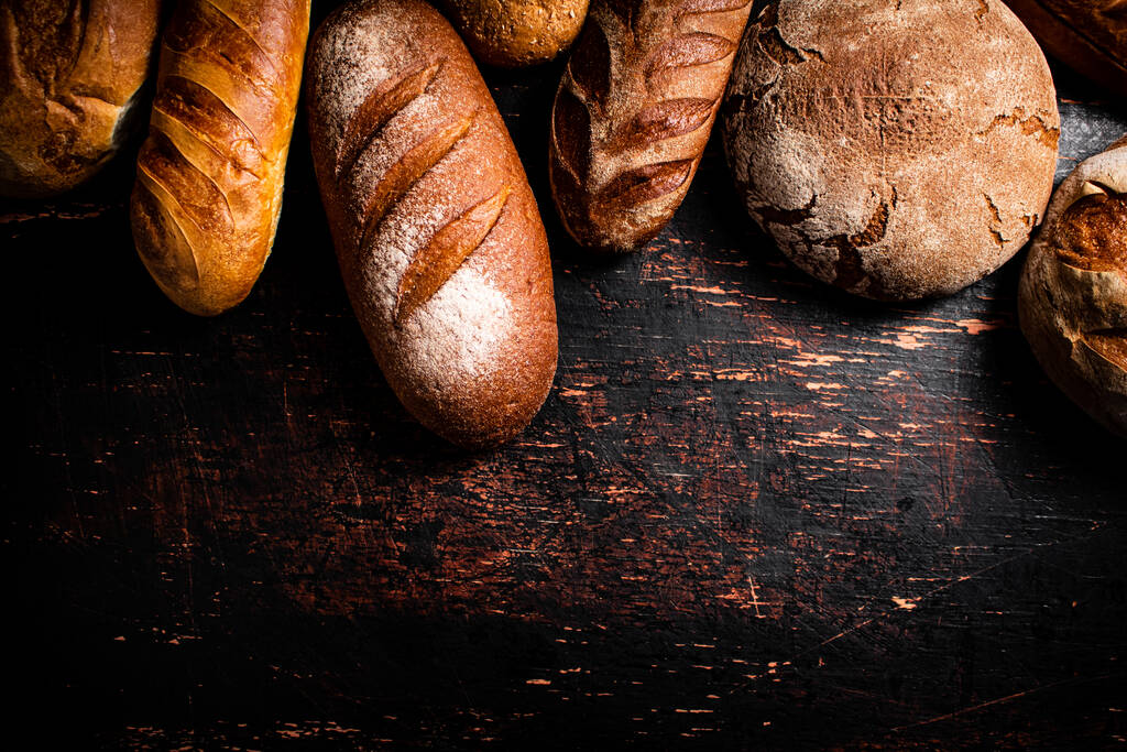 Différents types de pain frais croustillant. Sur un fond en bois. Photo de haute qualité - Photo, image