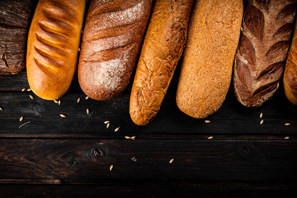 Taze taze ekmeğin farklı türleri. Ahşap bir arka planda. Yüksek kalite fotoğraf - Fotoğraf, Görsel