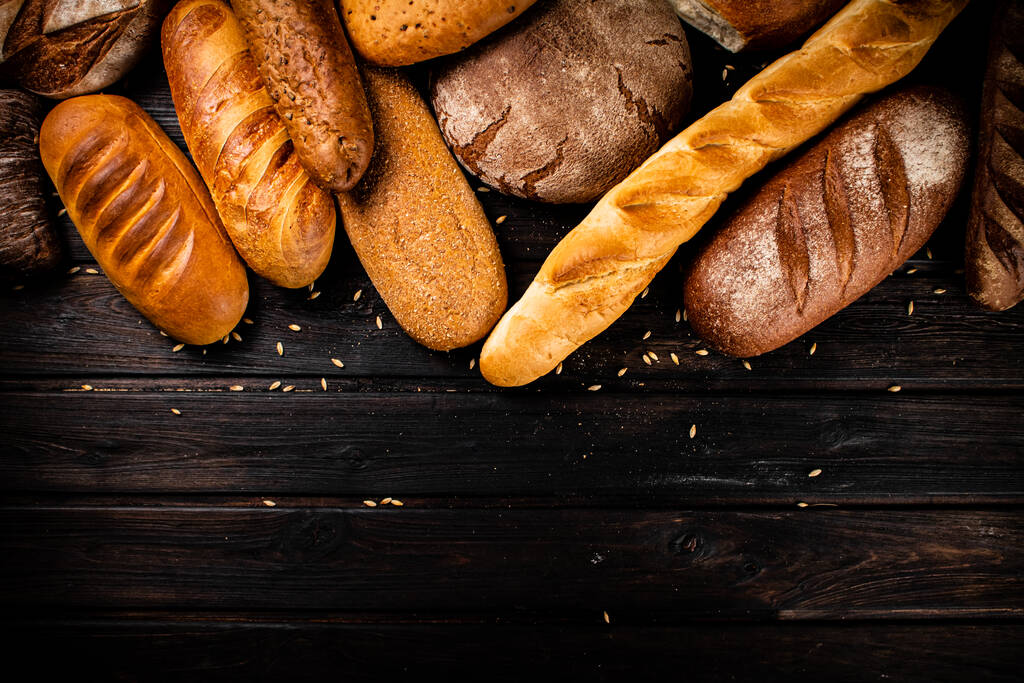 Erilaisia tuoretta leipää. Puupohjalla. Laadukas kuva - Valokuva, kuva