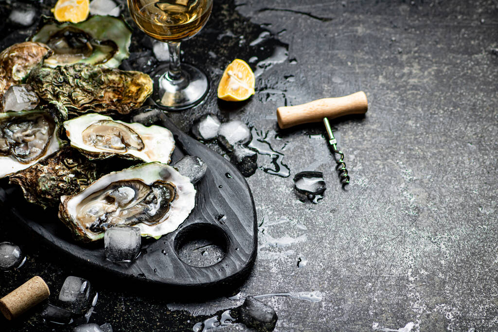 Fresh oysters on a cutting board. On a black background. High quality photo - Фото, изображение