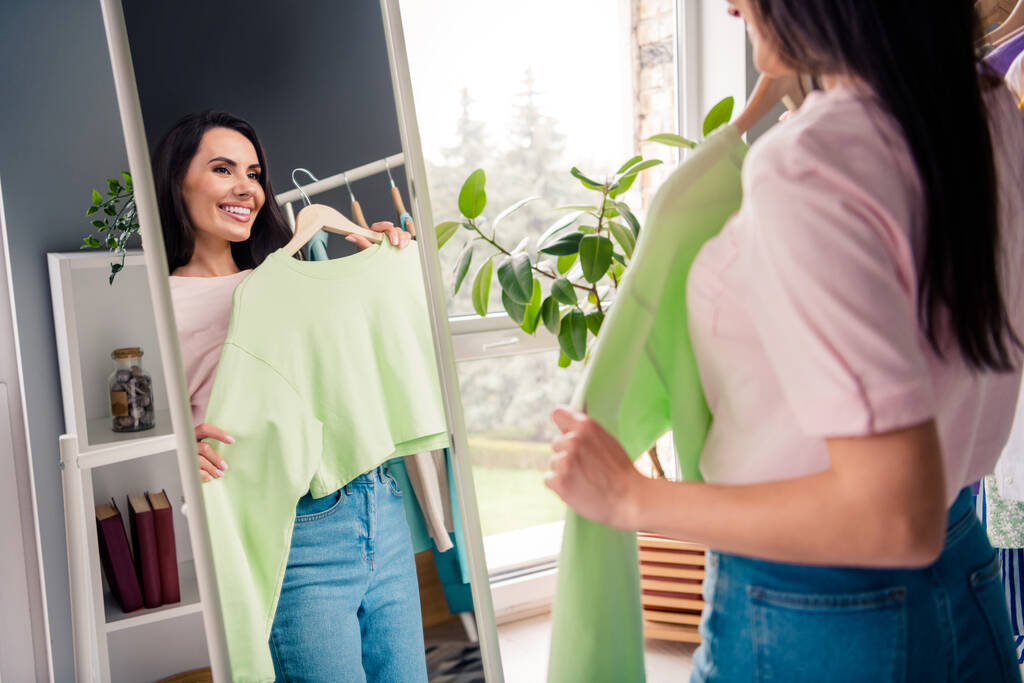 Photo of positive lady wybrać zielony modny koszula lustro wygląd cieszyć się jej nowy strój wygląd zakupu w salonie butikowym. - Zdjęcie, obraz