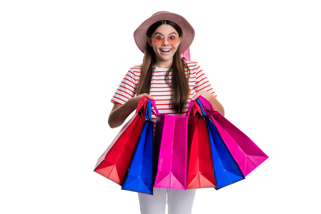 obraz ohromený dospívající dívka v obchodě s taškami. dospívající dívka v obchodě izolované na bílém. dospívající dívka v nákupním výprodeji na pozadí. teen dívka v nákupním prodeji ve studiu. - Fotografie, Obrázek