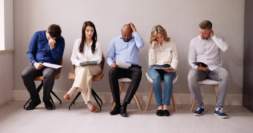 Business ihmiset ovat kyllästymässä istuessaan tuolilla odottamassa työhaastattelussa Office
 - Valokuva, kuva