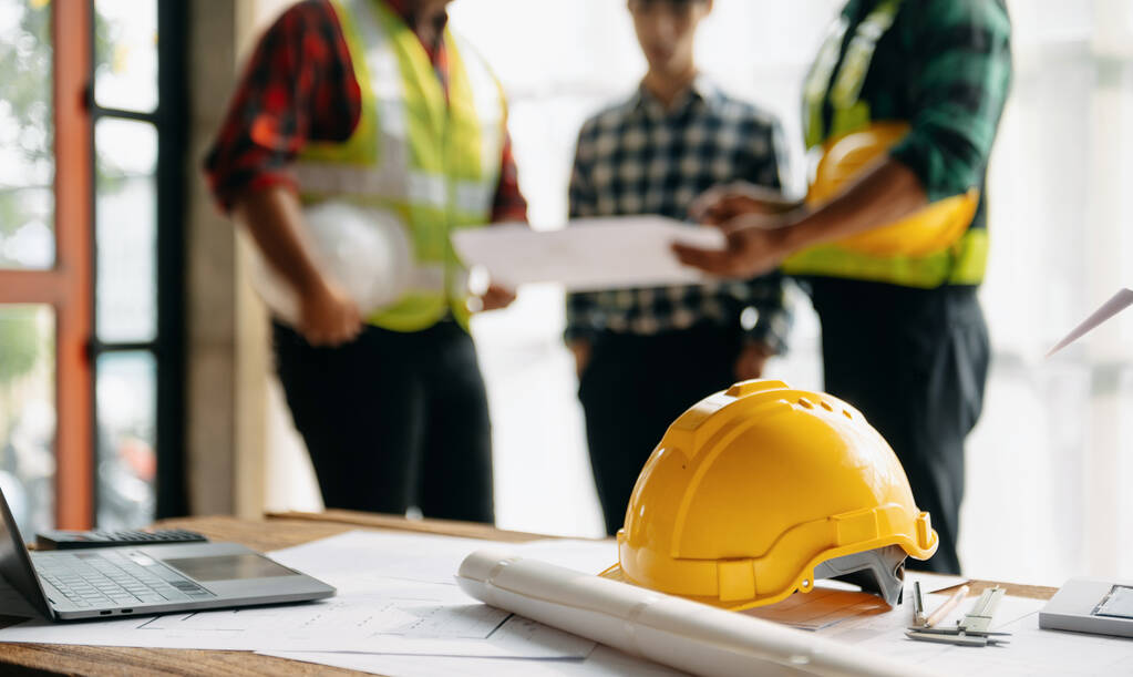Inženýrské týmy setkání pracovat společně nosit dělnické přilby na staveništi v moderním městě. - Fotografie, Obrázek