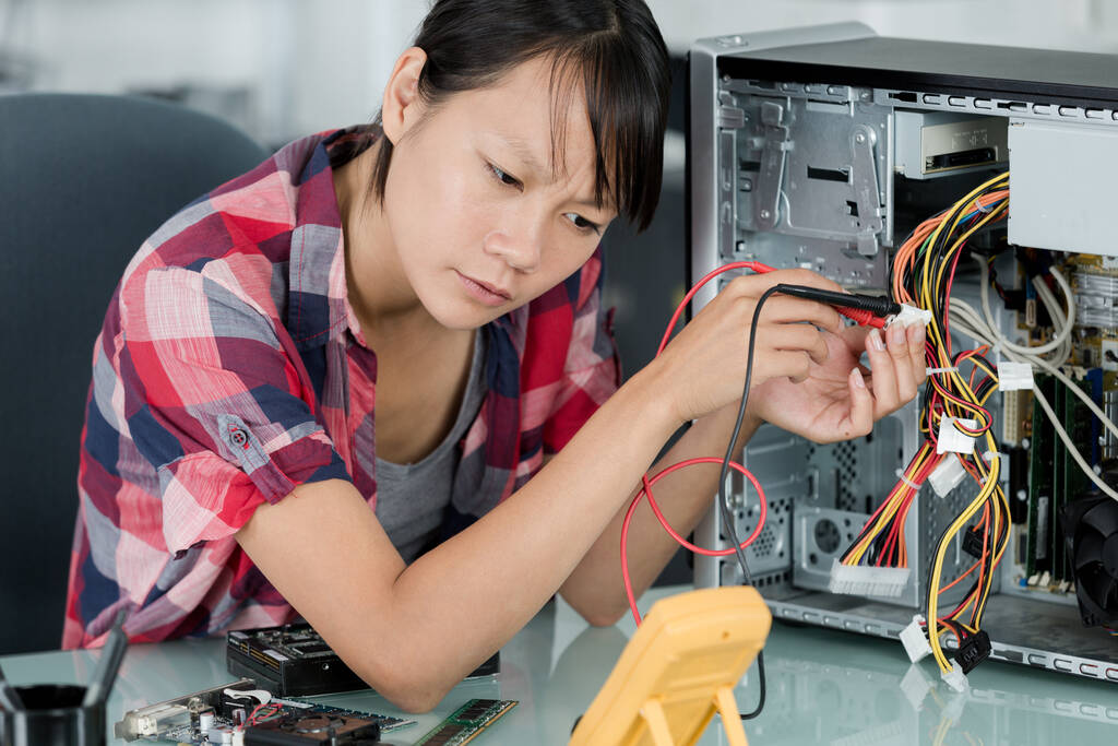 幸せな若い女性のPC技術者は電圧を測定し - 写真・画像