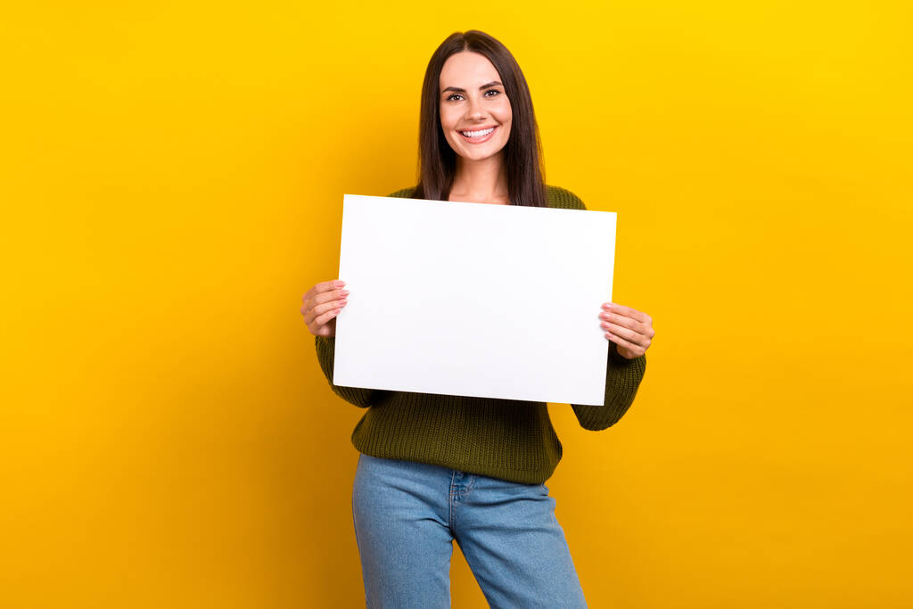Foto de brazos de sonrisa dentada agradable positivo sostiene la tarjeta de papel vacío espacio aislado en el fondo de color amarillo. - Foto, imagen