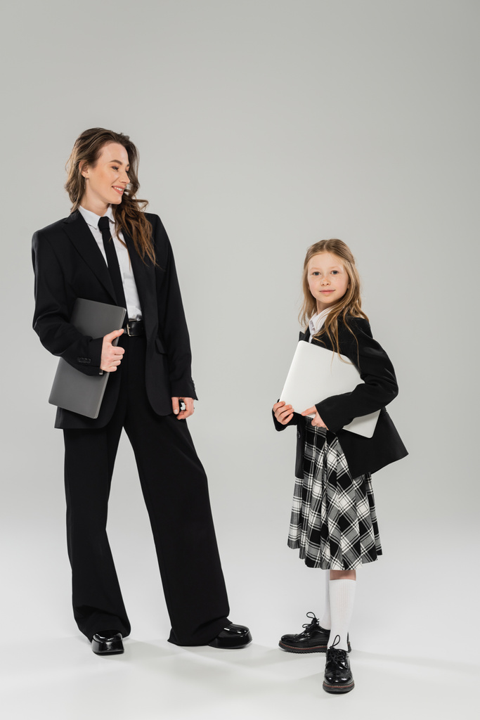Anne ve kız, dijital göçebelik, uzaktan çalışma, öğrenme, takım elbiseli mutlu iş kadını ve okul kızı birlikte dizüstü bilgisayarlarla stüdyoda, modern ebeveynlik  - Fotoğraf, Görsel