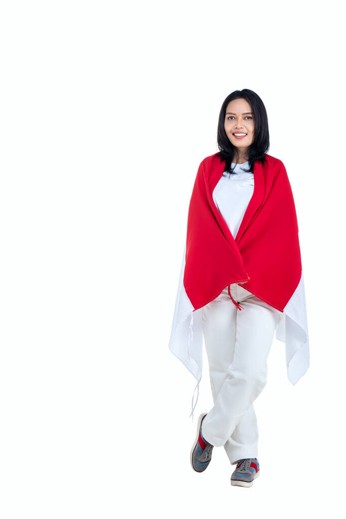 Indonesian women celebrate Indonesian independence day on 17 August by holding the Indonesian flag isolated over white background - Zdjęcie, obraz