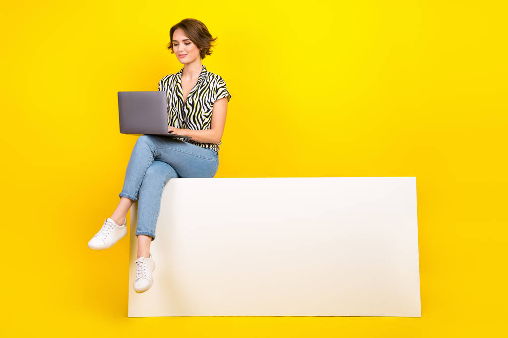 Photo of stunning lovely lady wear trendy clothes sitting podium use gadget typing email empty space isolated on yellow color background. - Photo, Image