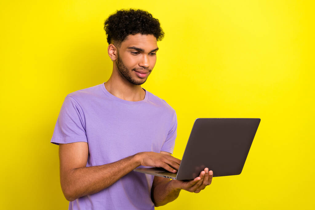 若いプログラム開発者の男の写真それは黄色の色の背景に隔離された彼のラップトップ技術にリモートで専門のスマートマネージャーの仕事. - 写真・画像