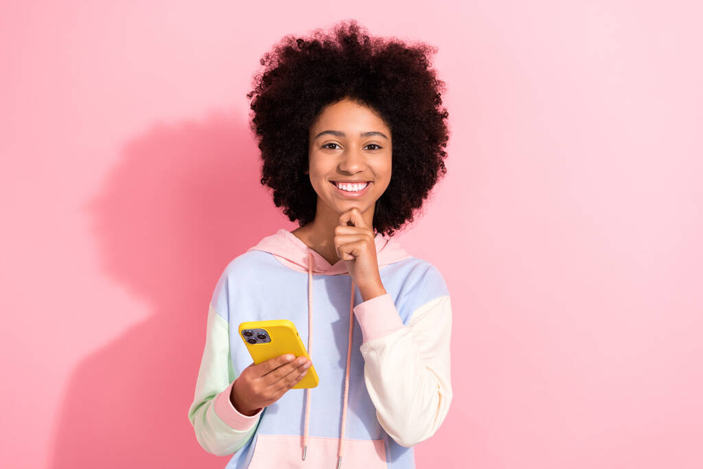 Foto de mente positiva encantadora menina toothy sorriso mão toque queixo segurar telefone inteligente isolado no fundo cor-de-rosa. - Foto, Imagem