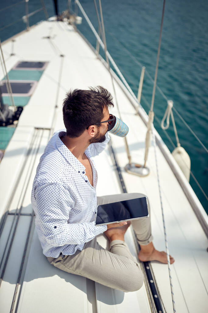 Uomo d'affari occasionale che lavora sullo yacht in una giornata di sole - Foto, immagini