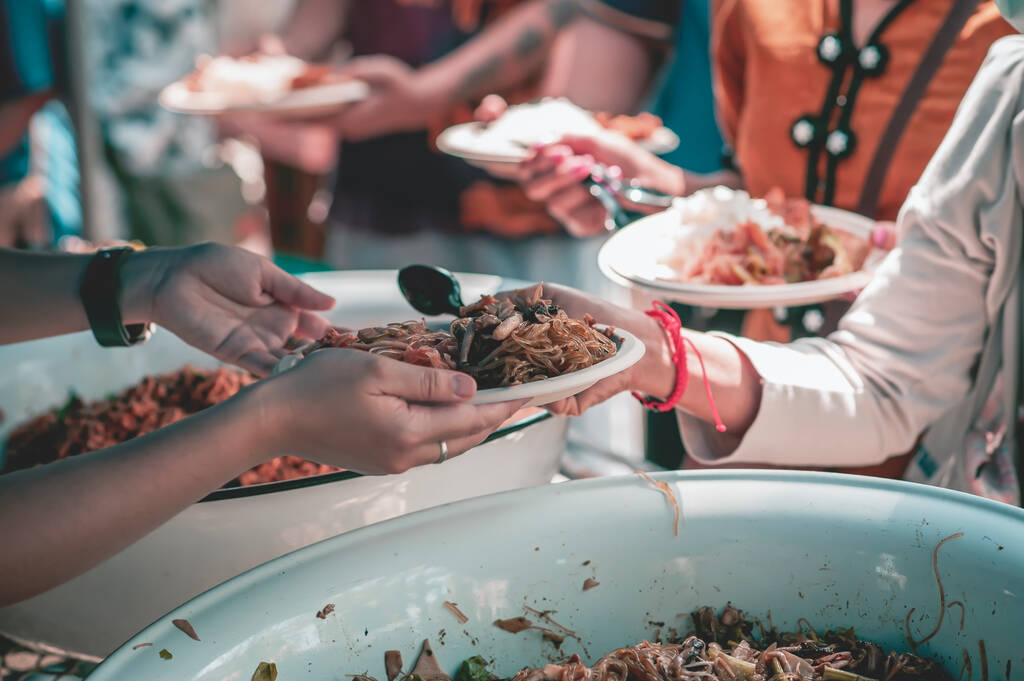 Voluntarios ofrecen comida gratis a los pobres: el concepto de compartir comida. - Foto, imagen