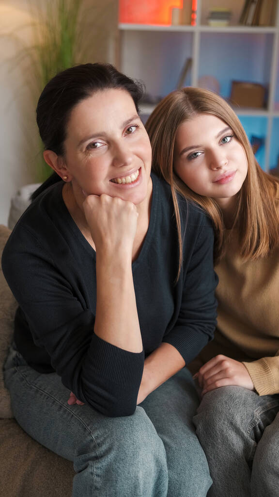 Familienporträt. Glückliche Beziehung. Lächelnde Mutter Teenager-Tochter genießt die gemeinsame Zeit auf der Couch im hellen Home Interieur. - Foto, Bild