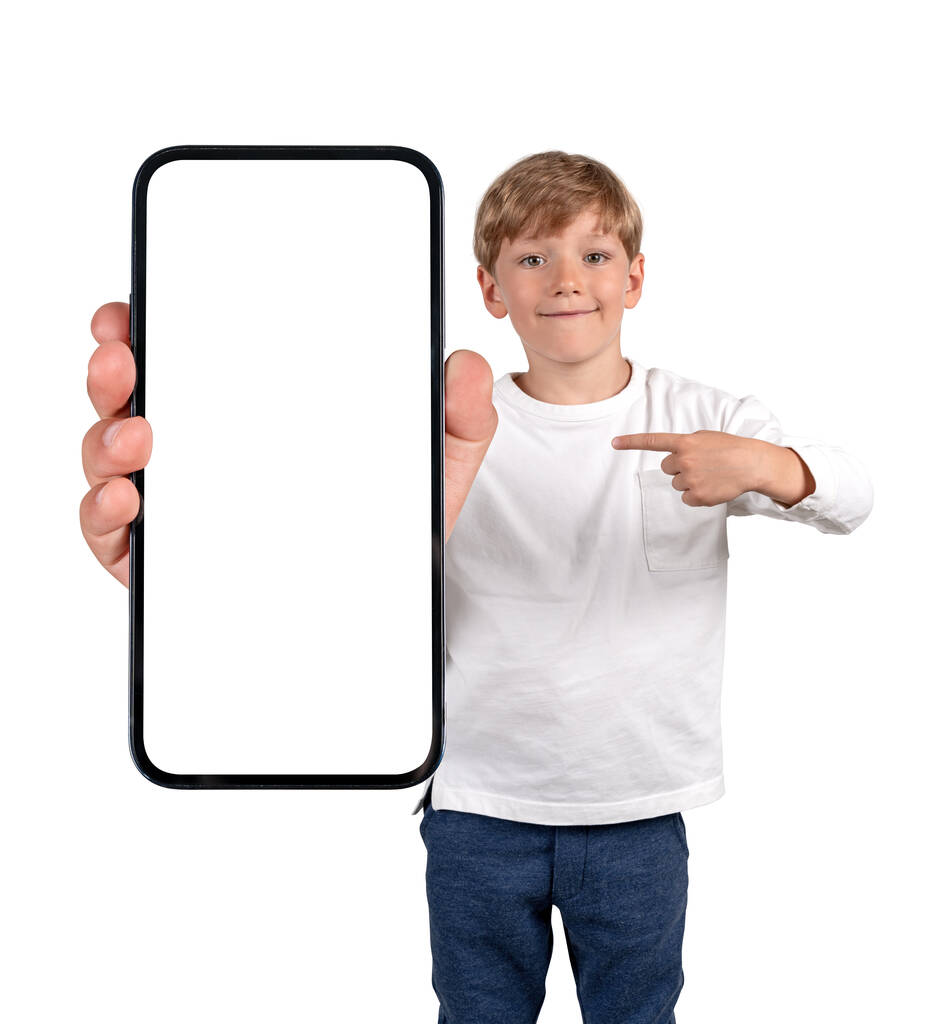 Poika poika hymyilee, sormi osoittaa älypuhelimeen mallintaa kopioi tilaa näytön, eristetty valkoisella taustalla. Käsite pelejä ja mobiilisovellus - Valokuva, kuva