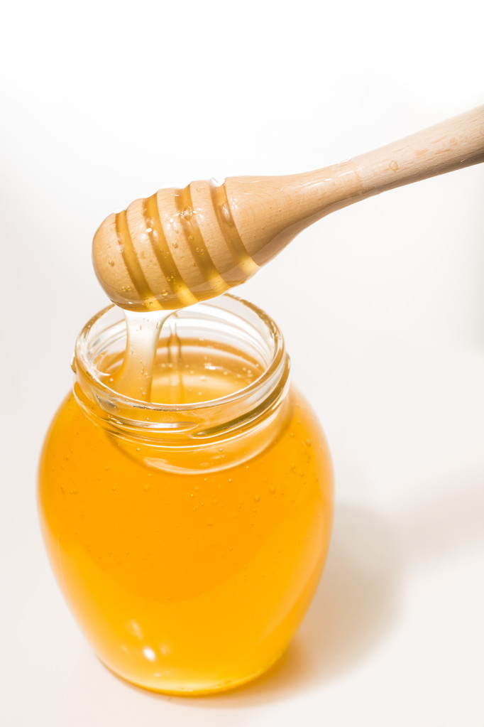 Csupor mézet, fából készült drizzler elszigetelt fehér background - Fotó, kép