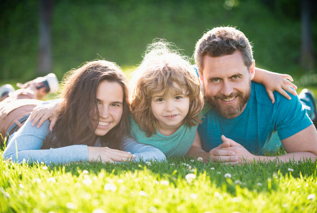 Parkta kucaklaşan mutlu bir ailenin portresi. Aile ve çocuk yazın dışarıda. - Fotoğraf, Görsel