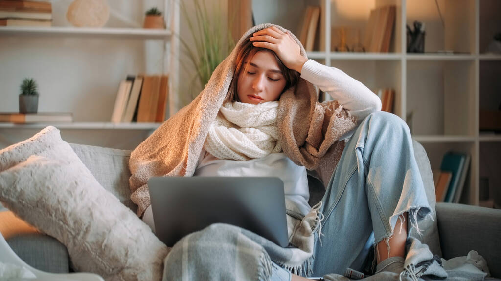 Sick work. Flu freelancer. Exhausted shivering woman wrapped in plaid remote online job laptop feeling unwell sitting sofa in living room home interior. - Photo, Image