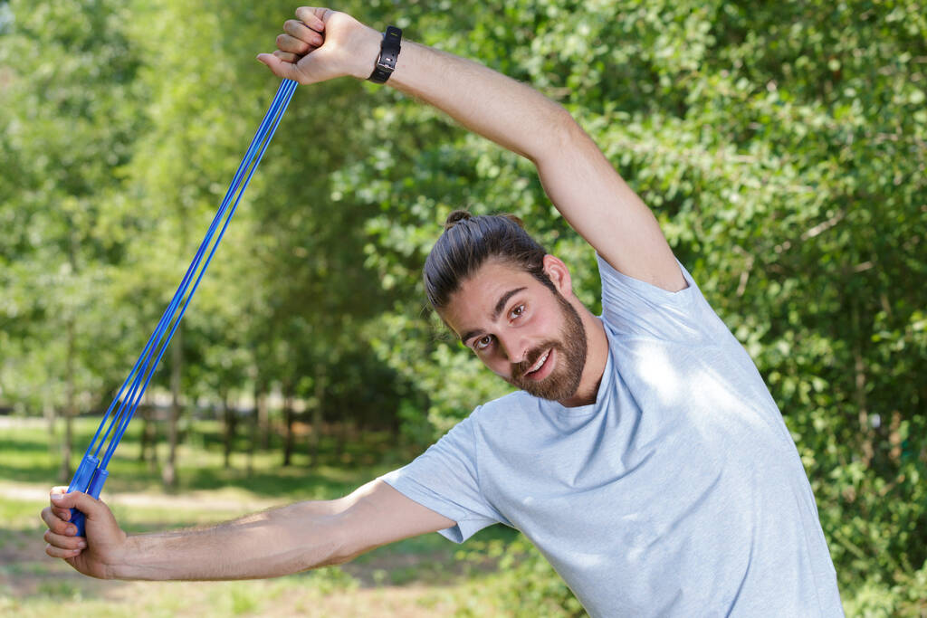 man doet stretching met elastiekje - Foto, afbeelding