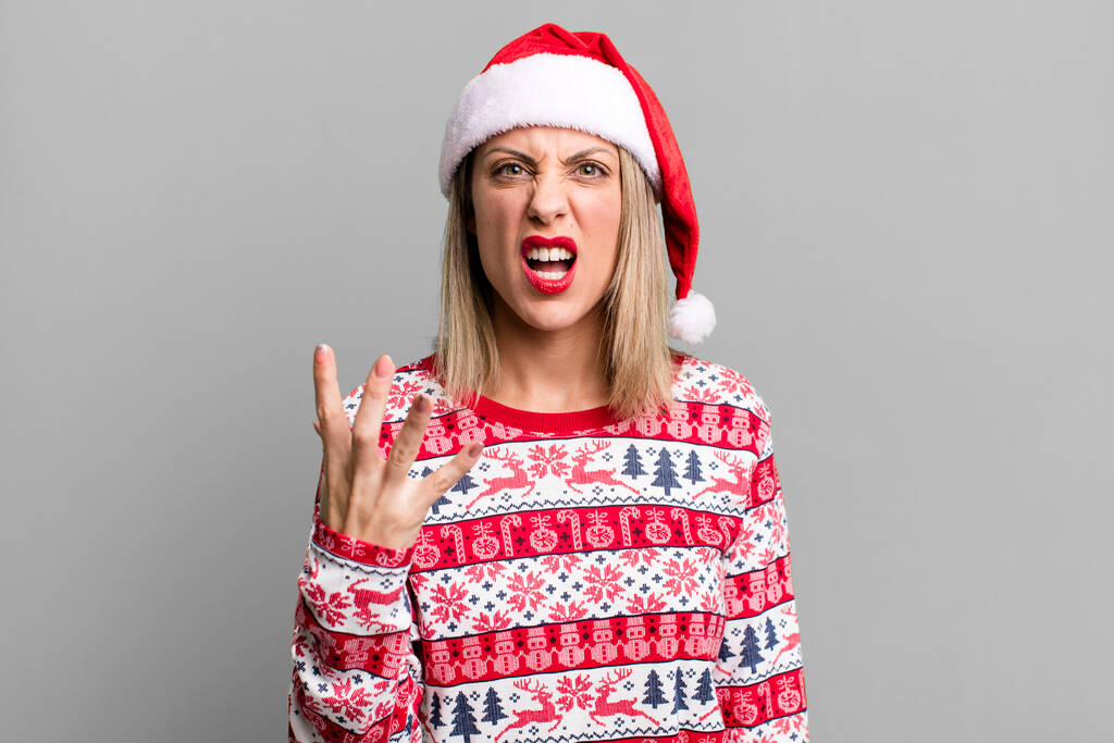 pretty blonde woman looking angry, annoyed and frustrated. christmas and santa hat concept - Foto, Imagen