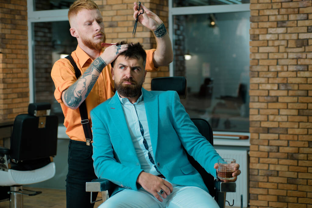 Hoja de afeitar. Barber - Shaves and Trims (en inglés). Los peluqueros trabajan para un tipo guapo en la peluquería. Preparación para el cabello es solo para el tipo apuesto. Cliente barbudo visitando peluquería - Foto, imagen