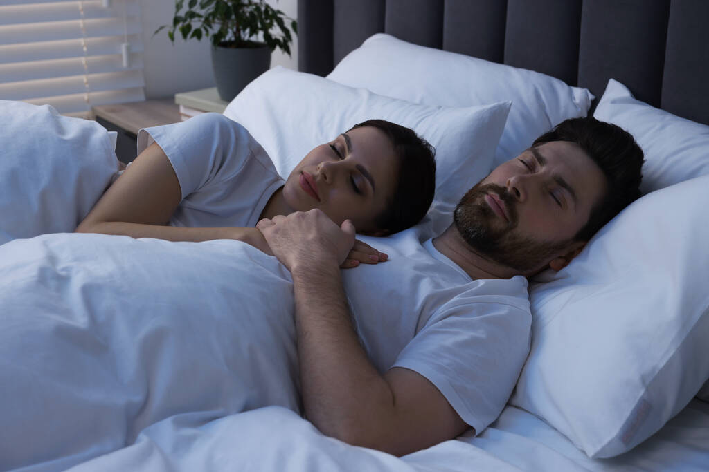 Υπέροχο ζευγάρι κοιμάται μαζί στο κρεβάτι το βράδυ - Φωτογραφία, εικόνα