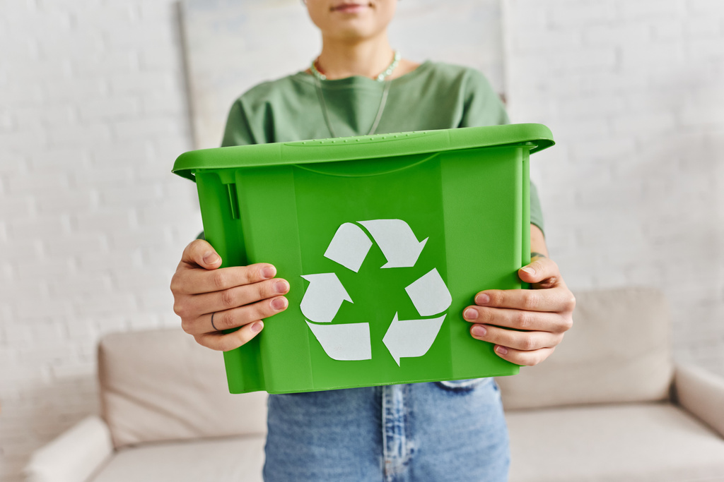 összpontosítani zöld műanyag doboz újrahasznosítási jel kezében termett nő áll otthon homályos háttér, fenntartható életmód és környezetbarát szokások koncepció - Fotó, kép