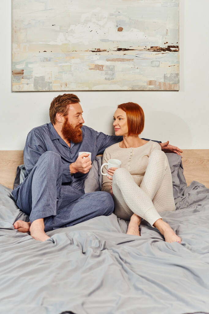 coffee and conversation, morning rituals, quality time, day off without kids, redhead and happy husband and wife, bearded man and woman holding cups, parents alone at home, lifestyle  - Photo, Image