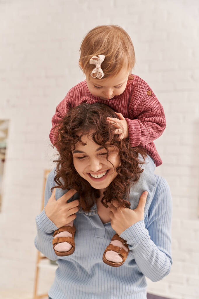 smiling woman with baby girl on shoulders, balanced lifestyle, mom daughter time, having fun together, quality time, work and life harmony, loving motherhood, happiness  - Photo, Image