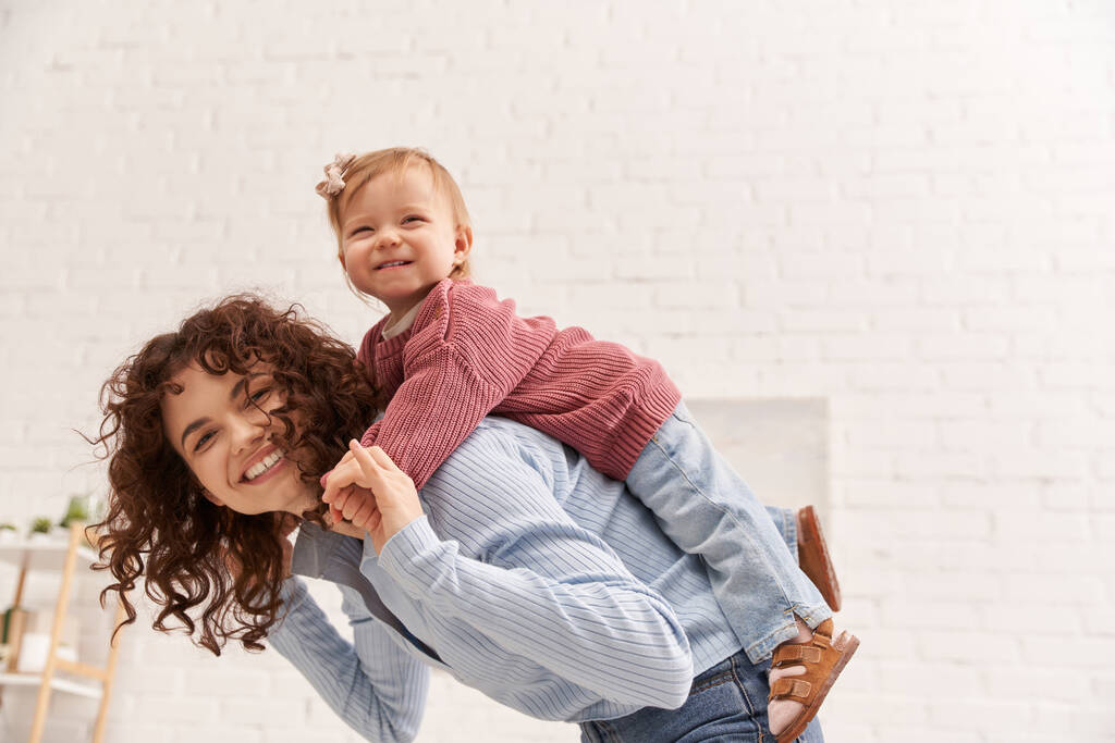 quality time, happiness, work and life harmony, cheerful woman with excited baby girl on back, balanced lifestyle, mom daughter time, having fun together, bonding, loving motherhood  - Photo, Image