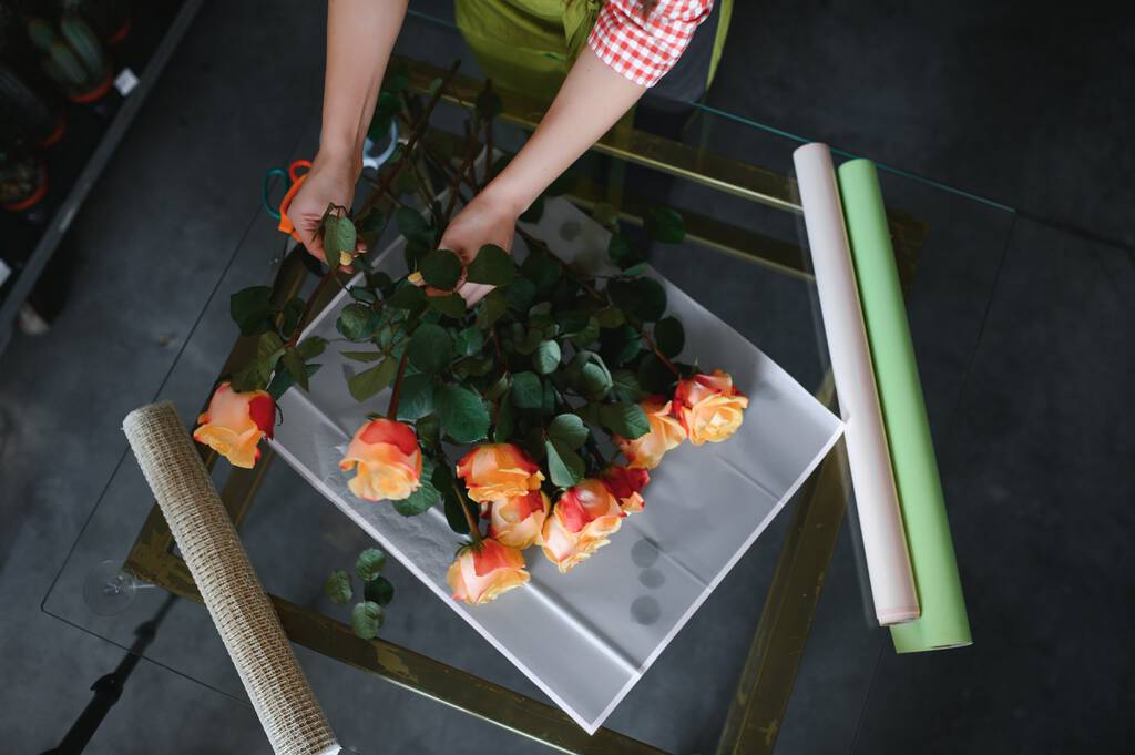 Vrouwelijke bloemist maakt mooi boeket bij bloemenwinkel. - Foto, afbeelding