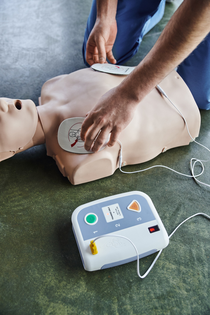 techniki resuscytacji serca, częściowy widok profesjonalnego ratownika medycznego stosującego defibrylatory na manekinach resuscytacyjnych, widok pod wysokim kątem, koncepcja opieki zdrowotnej i technik ratowania życia - Zdjęcie, obraz