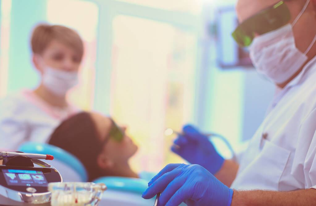 Человек-дантист, работающий над зубами своих пациентов. - Фото, изображение