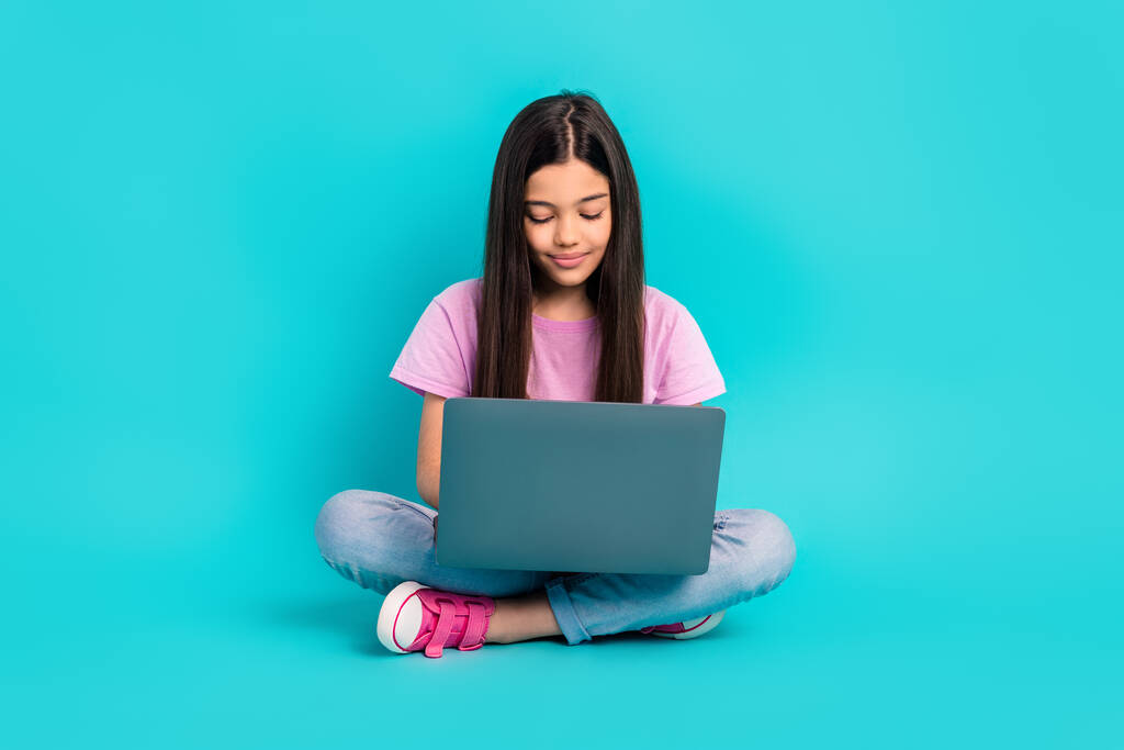 Plná délka fotografie malých dětí brunetky vlasy sedí studuje netbook dálkové on-line vzdělávání kurzy izolované na akvamarínové pozadí. - Fotografie, Obrázek