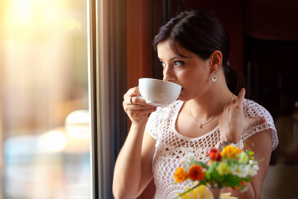 Retrato de uma menina feliz em um café com uma caneca na mão - Foto, Imagem