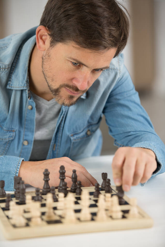 Egy fiatal férfi sakkozik. - Fotó, kép