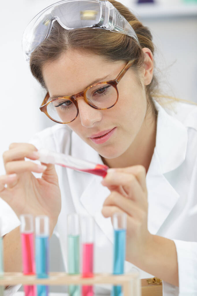 Жінка-лаборант бере аналіз крові з пробірки
 - Фото, зображення