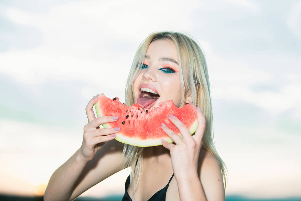 Closeup portrait of young blonde sensual woman eating watermelon. Tropical vacation travel sexy girl concept - Photo, Image